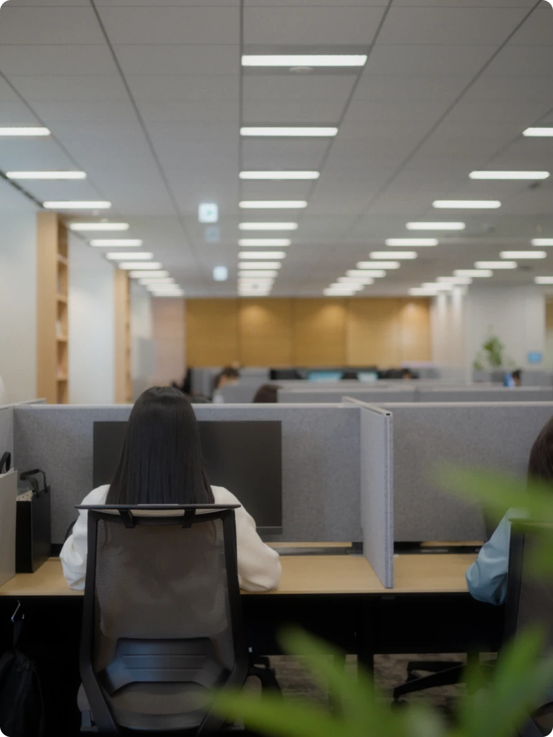 仕切りのある席で業務に取り組む社員